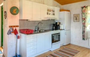 een keuken met witte kasten, een wastafel en een koelkast bij Holiday Home Nässjö Nässjö in Nässjö