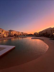 a swimming pool in a resort at sunset at Le Voyage Holiday Home Marzamemi in Marzamemi