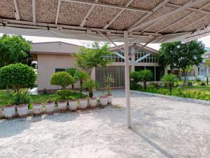 a pavilion with potted plants in front of a building at Baagh-e-sakoon in Islamabad