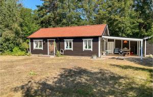 a small cabin with a red roof in a yard at 2 Bedroom Beautiful Home In Löderup in Löderup +15 photos