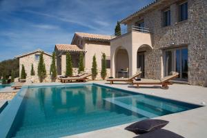 a swimming pool in front of a house at Ionian Horizon Villas in Tsoukalades