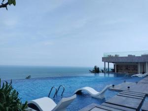 a swimming pool with a view of the ocean at Golden Sands Bayfront Mũi Né in Mui Ne