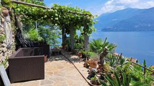 a patio with plants and a view of a lake at Casa Lago Azzurro Atelier in Cannobio