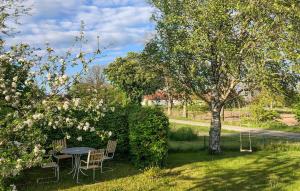 GärsnäsGorgeous Home In Gärsnäs With Wifi的院子里有一棵树，院子里有一张桌子和几把椅子 更多22张照片
