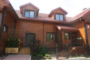 une maison en bois avec une clôture devant elle dans l'établissement Cztery Pory Roku, à Białowieża