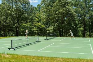two women playing tennis on a tennis court at The Cardinal at Buckhorn Hollow in McEwen