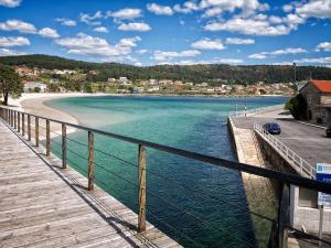 a bridge over a body of water with a beach at Areal de Esteiro in Esteiro-Muros