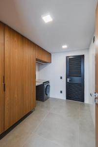 eine Küche mit Holzschränken und einer Mikrowelle in der Unterkunft Rio Quente Resorts - Incasa Private Residence Club - Soft Opening in Rio Quente