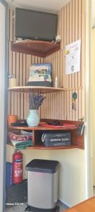 a shelf with a television and a vase on it at charmant mobil home de patricia et bruno in Sainte-Croix-de-Verdon +7 photos