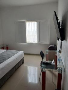 a bedroom with a bed and a desk with a laptop at Zar San Luis Potosi in San Luis Potosí +12 photos