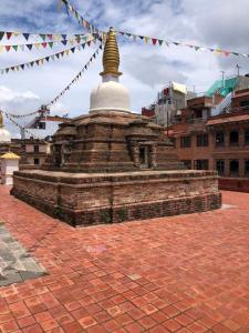 a pagoda with a gold top on top of a brickickedstrationstrationstration at Kathmandu Family Home in Kirtipur