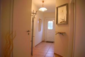 a hallway with a white door and a mirror at 6 Personen Familienferienhaus mit Sauna, Whirlpool zwei Toiletten und Kaminofen in Otterndorf in Otterndorf +7 photos