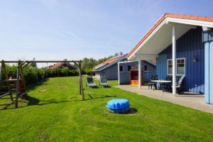 a yard with a blue ball on the grass at 6 Personen Familienferienhaus mit Sauna, Whirlpool zwei Toiletten und Kaminofen in Otterndorf in Otterndorf