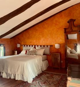 a bedroom with a white bed and an orange wall at La Foresteria at Casaforte Bergum by the Gates of Cividale del Friuli 