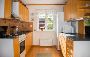 a kitchen with wooden cabinets and a white refrigerator at Cozy Home In Ålem With Kitchen in Ålem