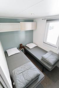 a small room with two beds and a window at Camping Le Littoral in Le Grau-dʼAgde