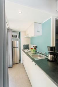 a kitchen with a sink and a refrigerator at Camping Le Littoral in Le Grau-dʼAgde +9 photos