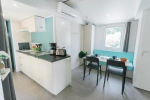a kitchen with a counter and a table and chairs at Camping Le Littoral in Le Grau-dʼAgde
