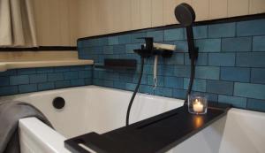 ein Badezimmer mit einer Badewanne und einer Kerze auf einem Tisch in der Unterkunft 8 Personen Hausboot mit Hot Tub, Sauna, Kaminofen, Klimaanlage, Lounge, Sonnendeck und Garten mit Buddelschiff direkt hinterm Deich in Otterndorf in Otterndorf + 66 Fotos