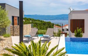 a patio with two chairs and a swimming pool at Holiday home Villa Vrbnik by Villas guide in Vrbnik