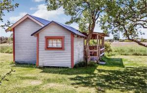 a small house in a field with a tree at Lasses Stuga in Visby