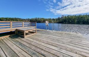 a wooden dock with a bench on top of a lake at Lovely Home In Hindås With Kitchen in Hindås