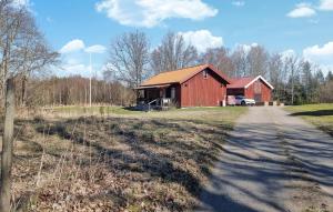 a red barn on the side of a road at Lovely Home In Hindås With Kitchen in Hindås