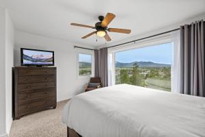 a bedroom with a ceiling fan and a large window at 838B Wapiti Dr in Fraser