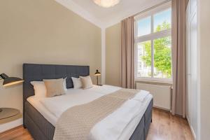 ein Schlafzimmer mit einem großen Bett mit einem großen Fenster in der Unterkunft Villa Carmen Strandperle in Ahlbeck + 18 Fotos