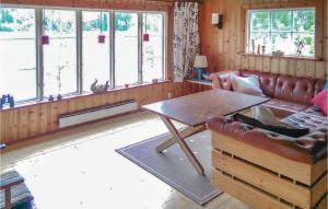 a living room with a leather couch and a table at 3 Bedroom Cozy Home In Åmål in Åmål +15 photos