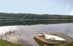 a boat sitting on the shore of a lake at 3 Bedroom Cozy Home In Åmål in Åmål
