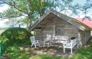 a log cabin with a table and chairs in front of it at Holiday Home Bön Granbacken Brålanda in Sörbo
