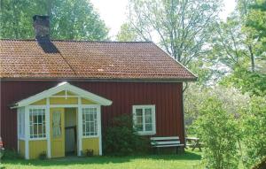 a red house with a bench in front of it at Holiday Home Bön Granbacken Brålanda in Sörbo