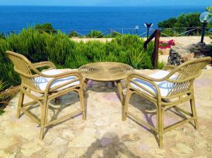 einen Tisch und zwei Stühle sowie einen Tisch und Stühle in der Unterkunft Il Casale San Vito in San Vito lo Capo