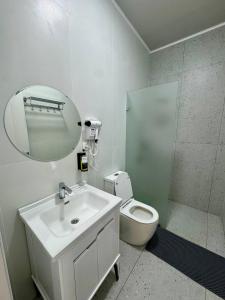a bathroom with a sink and a toilet and a mirror at BOG'DON GRAND Hotel in Tashkent