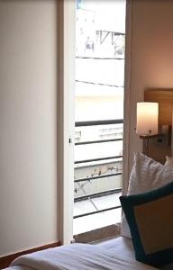 a bedroom with a door open to a balcony at Luxos by Proximus in Bengaluru