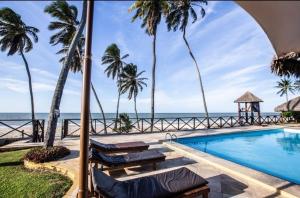 a swimming pool with palm trees and the ocean at Ecoparadise Flat 103 in Caucaia