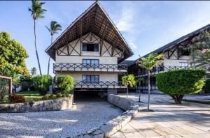 a large white building with palm trees in front of it at Ecoparadise Flat 103 in Caucaia