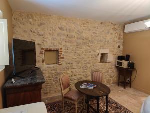 a living room with a table and a stone wall at Les communs du Château du Sollier - Charme Calme Confort Climatisation à 5mn du péage in Bourges