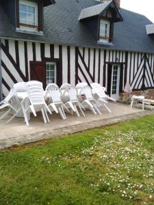 um grupo de cadeiras brancas sentadas fora de um edifício em Gite De Malvoue em Vimoutiers