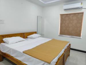 a bedroom with a bed and a window at Magnolia Villa Luxury 3 Bedroom Apartments in Visakhapatnam