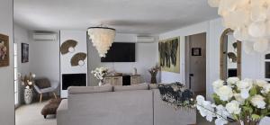 a living room with a couch and a chandelier at Villa Can Kiko Ibiza in San Jose