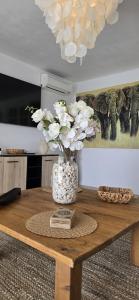 a vase with white flowers on a wooden table at Villa Can Kiko Ibiza in San Jose +49 photos
