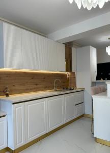una cucina con mobili bianchi e un lavandino di Studio KMS Mamaia Nord a Mamaia Nord - Năvodari