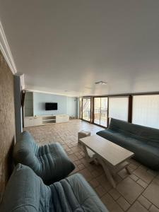 a living room with two blue couches and a table at Sunny Side in Batumi +4 photos