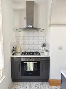 a kitchen with a black stove top oven at Entire Apartment by City Centre & Harbourside in Bristol +2 photos