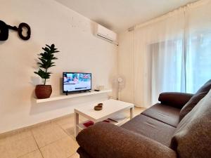 a living room with a couch and a tv at AYRES APART in Calafell