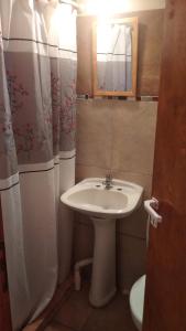 een badkamer met een wastafel en een spiegel en een toilet bij Casa de Olga in Tandil +1 foto