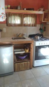 een keuken met een spoelbak en een fornuis bij Casa de Olga in Tandil