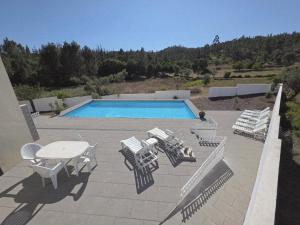 a patio with a table and chairs and a pool at Casas da Vila in Vila de Rei